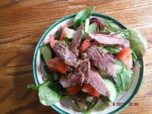 Salad greens mixed with romaine lettuce and topped with veggies and grilled leftover steak.